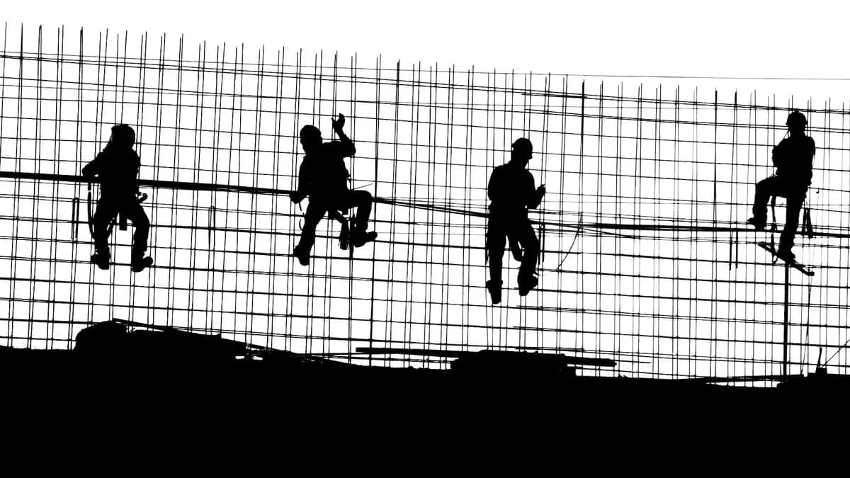 Trabajadores de la construcción en México sobre una estructura de fierro