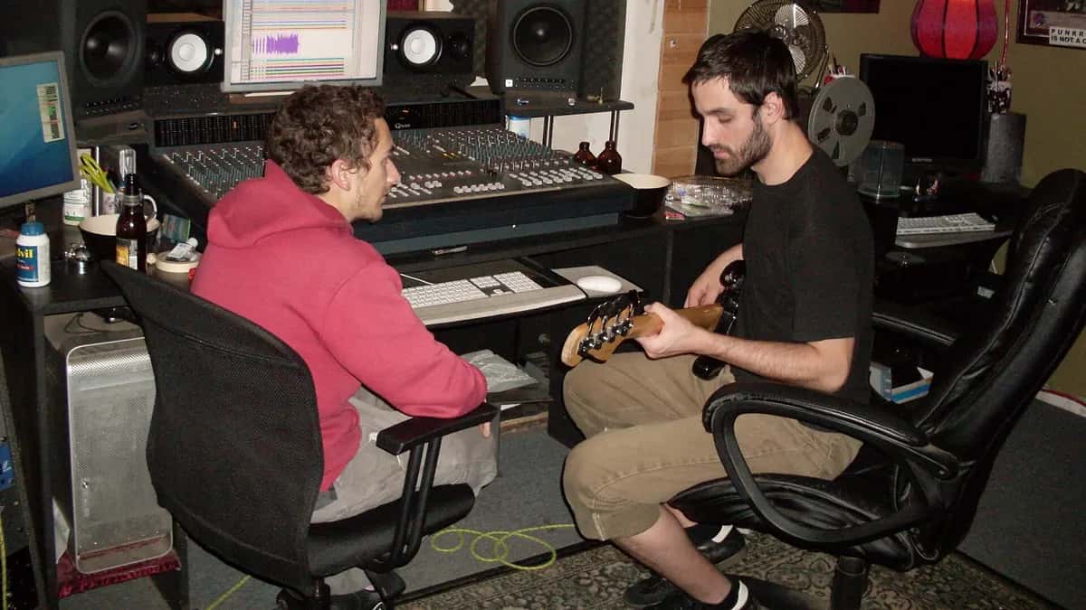 Two musicians working in a recording studio