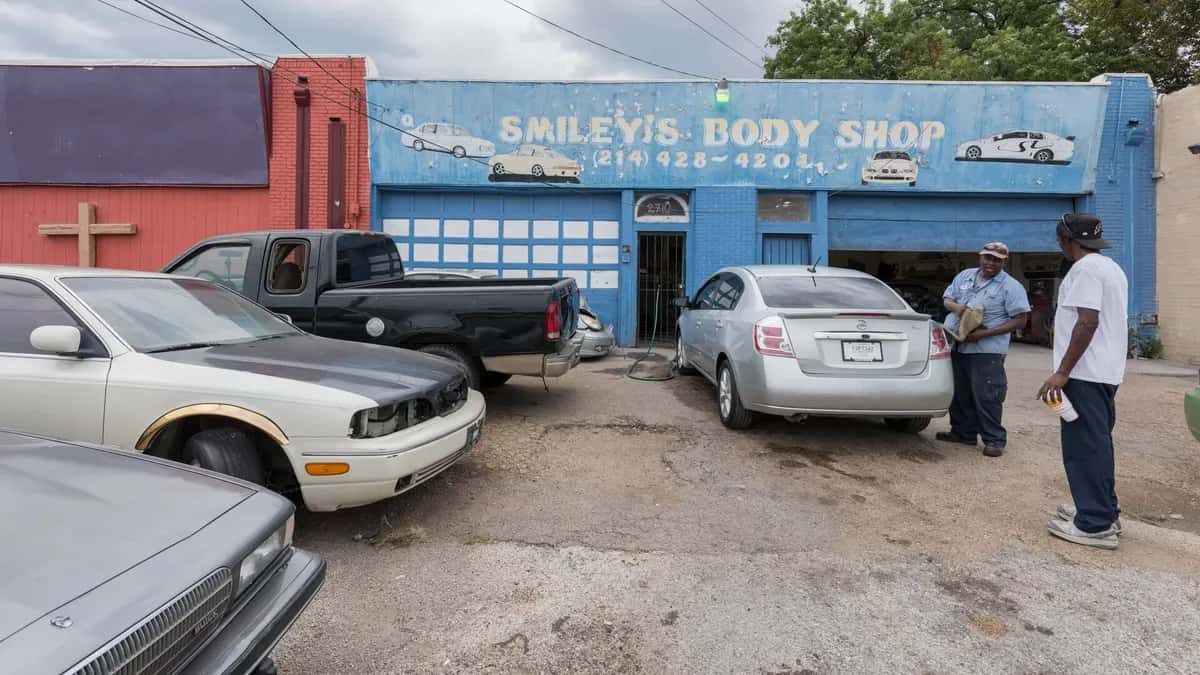 Taller de desabolladura y pintura con autos estacionados afuera