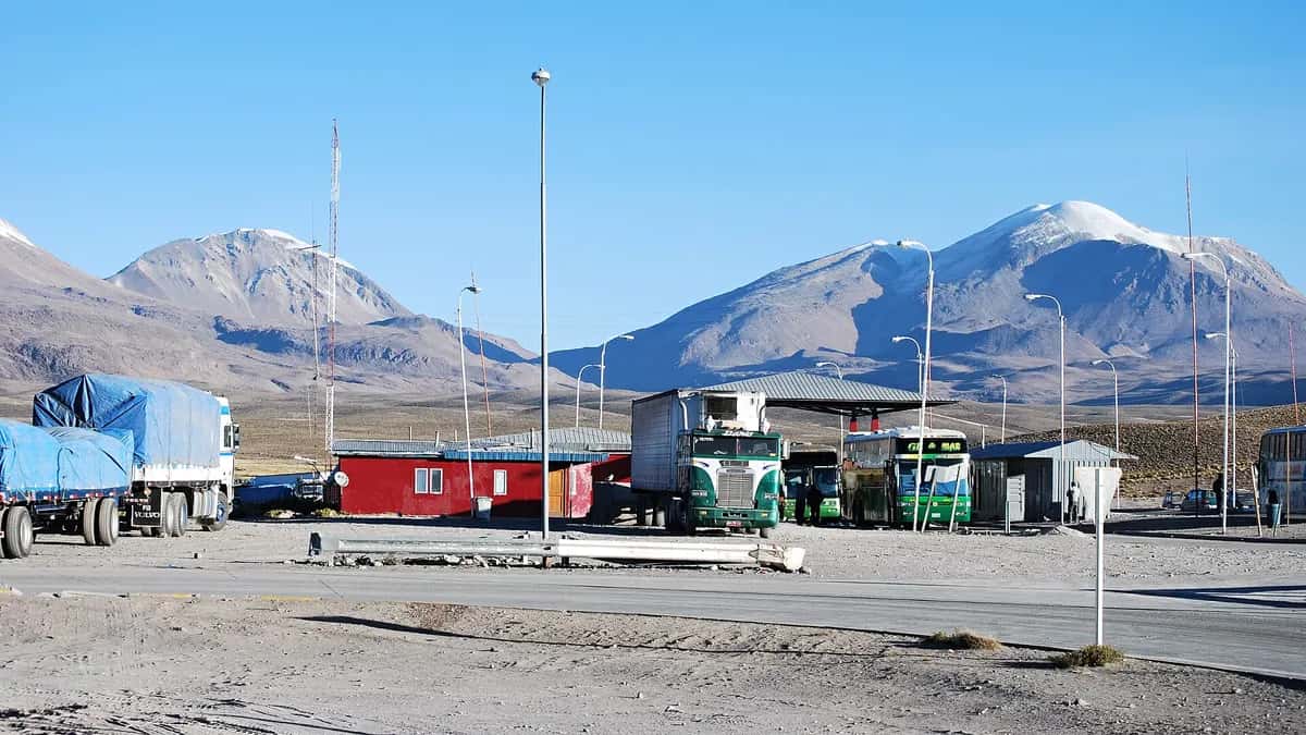 Border crossing on the altiplano with trucks and snow-capped volcanoes