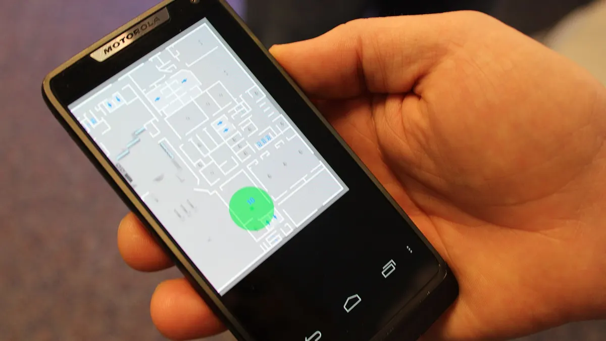 Hand holding a smartphone with a map on the screen