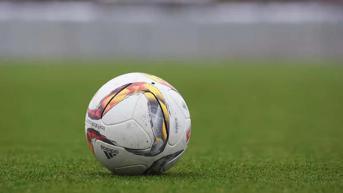 Bola de futebol sobre o gramado de um campo