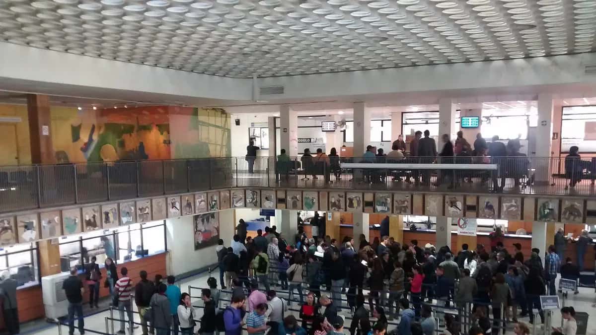 Interior de um escritório do Registro Civil em Santiago com pessoas aguardando atendimento