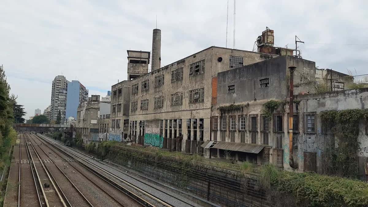 Fachada traseira da fábrica IMPA vista dos trilhos da ferrovia Sarmiento, em Buenos Aires