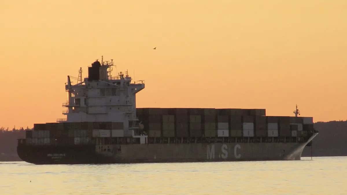 Container ship sailing at sunset